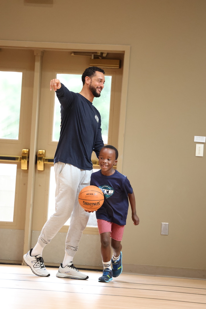A teenage basketball player going over a play with her coach