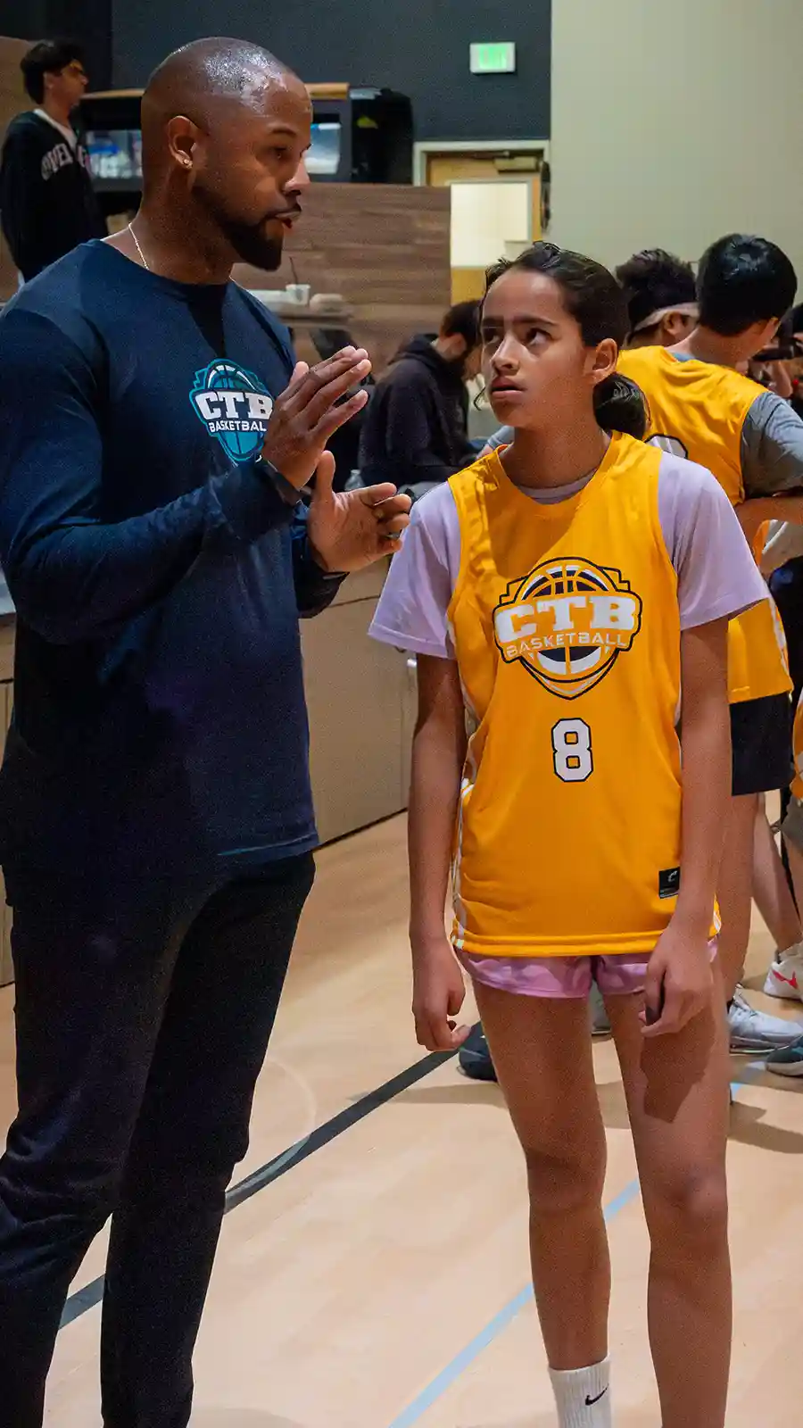 A young female basketball player listening to their coach during a game